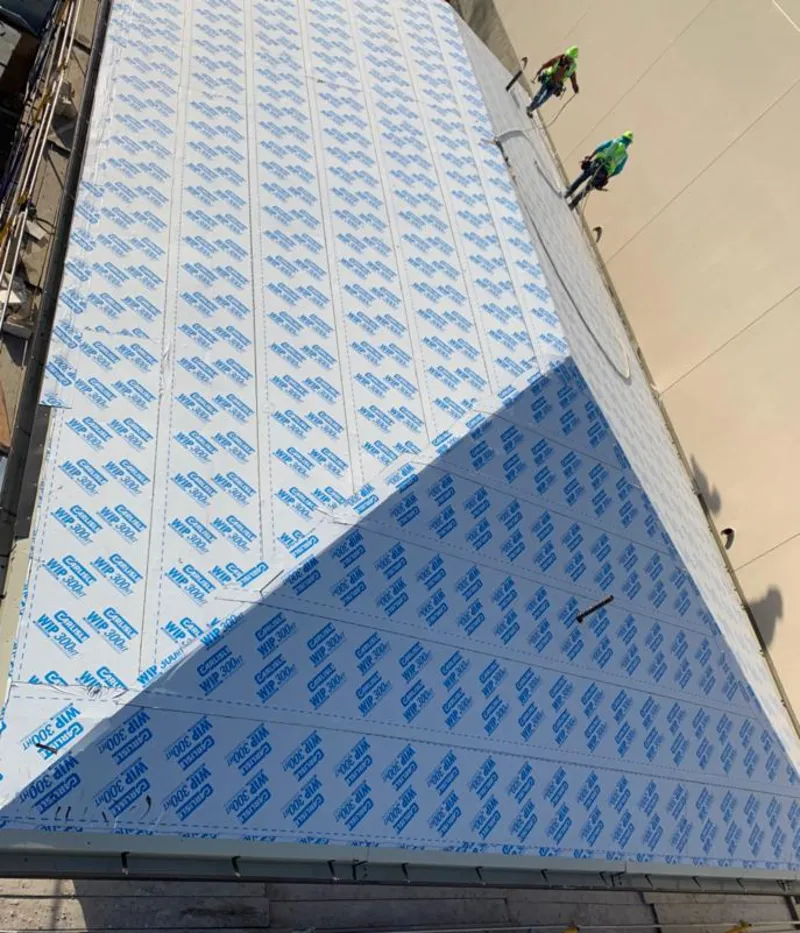 Professional roofers installing underlayment on a metal roof in Clay